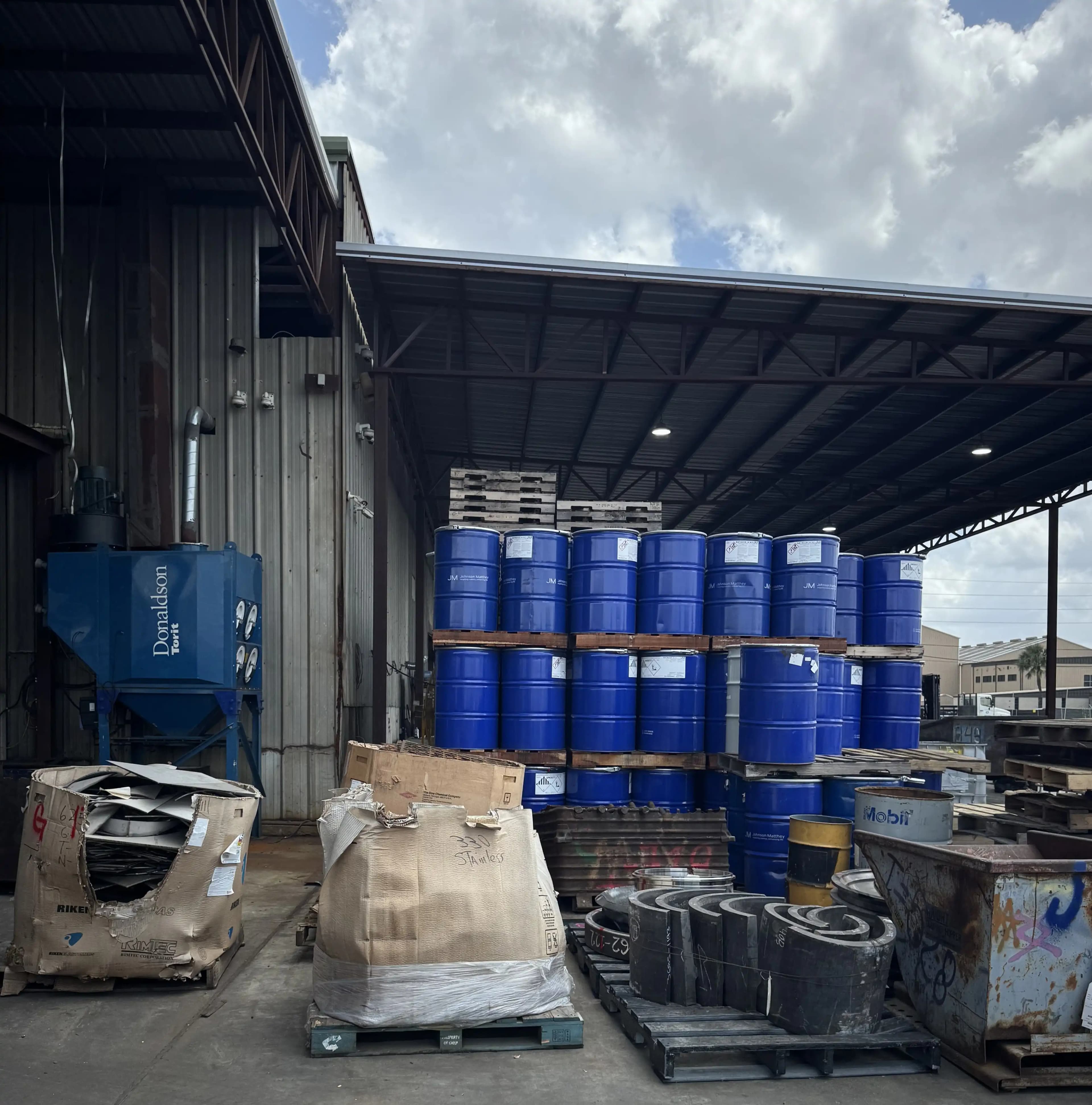 Tambores azules apilados afuera de una bodega en Houston