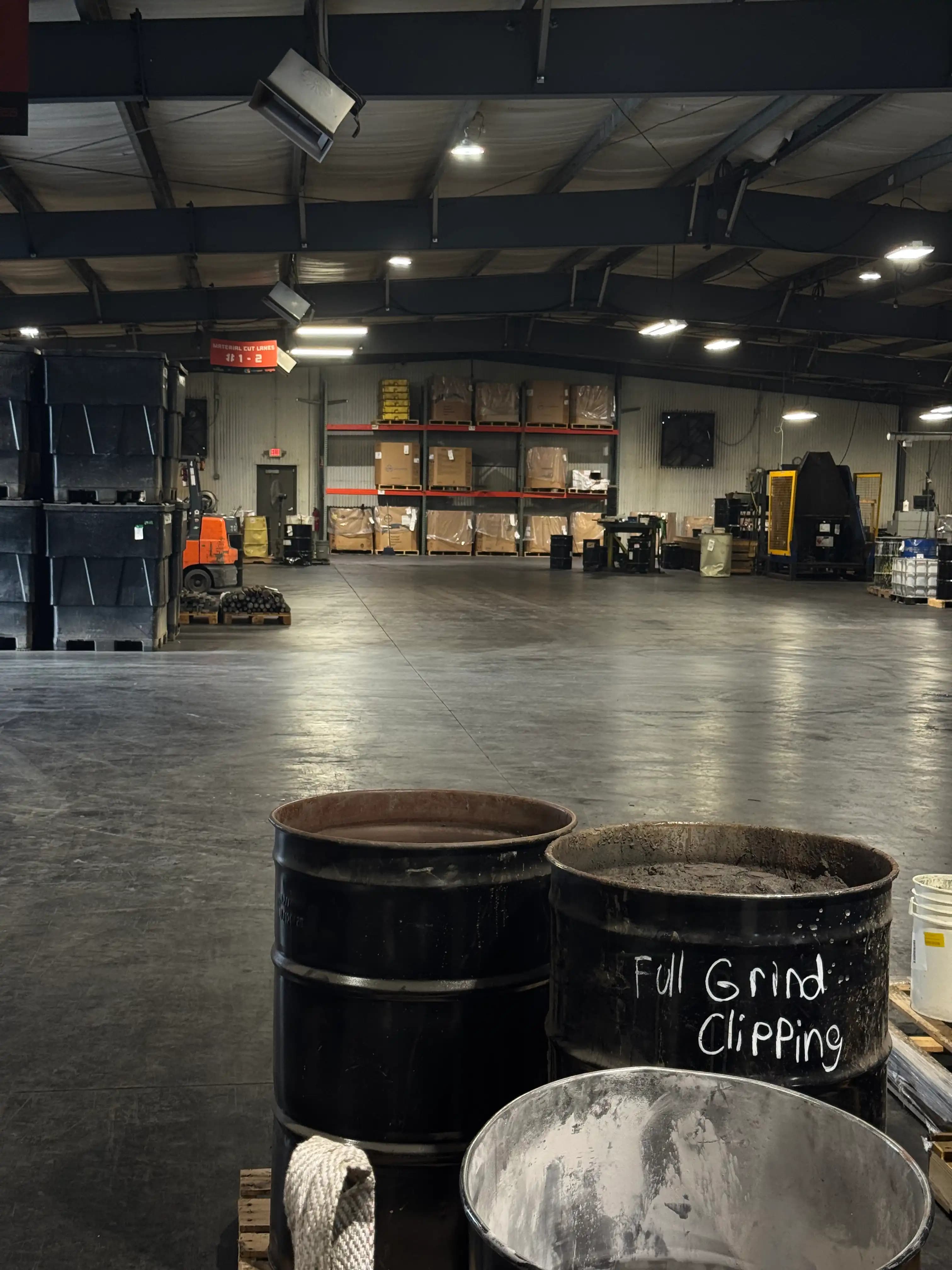 Area de grinding en bodega con tambores industriales